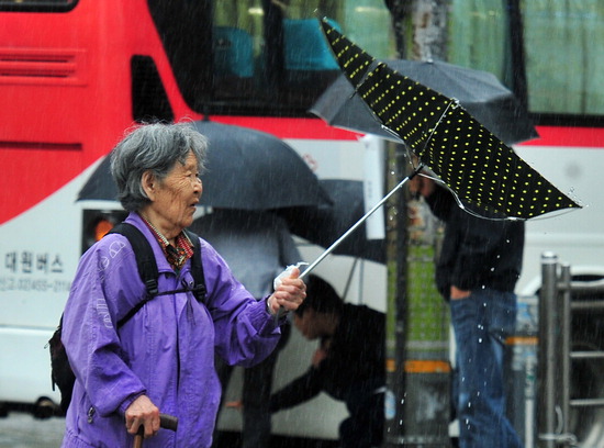 ▲ 경기 도심에 기습적으로 많은 비가 내린 18일 오후 성남시 분당구 미금역에서 한 할머니의 우산이 뒤집히고 있다. 성남=홍승남 기자 nam1432@kihoilbo.co.kr