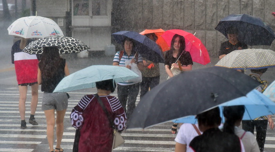 ▲ 장마전선의 영향으로 폭우가 내린 10일 인천시 남동구 구월동의 한 거리에서 시민들이 우산을 쓰고 발걸음을 재촉하고 있다.   이진우 기자 ljw@kihoilbo.co.kr