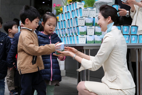 ▲ 28일 오전 서울 중구 대한항공 서소문사옥에서 열린 식목일 맞이 화분 나눔 행사에서 직원들이 어린이들에게 화분을 나눠주고 있다.  <대한항공 제공>