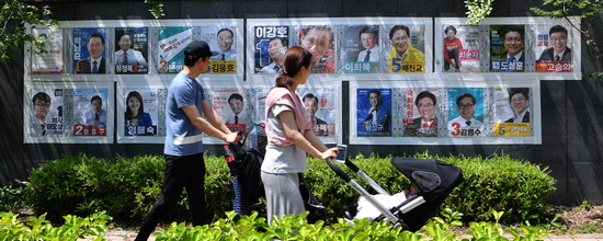 ▲ 3일 인천시 남동구 논현동의 한 아파트 단지 앞에서 시민들이 지방선거 후보자들의 벽보를 보며 지나가고 있다.  이진우 기자 ljw@kihoilbo.co.kr