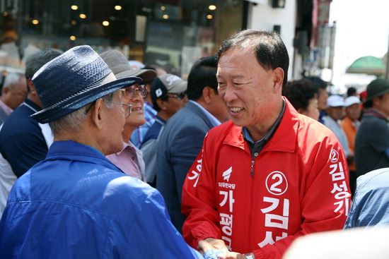 ▲ 자유한국당 김성기 가평군수 후보가 가평읍 장날을 찾은 군민들과 인사를 나누고 있다.