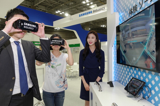 ▲ 일본 도쿄에서 27일부터 3일간 열리는 바이오파머 엑스포 2018에 마련된 삼성바이오로직스 전시관에서 참관인들이 VR을 통해 생산시설 등을 감상하고 있다. <삼성바이오로직스 제공>