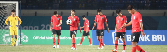 ▲ 한국 U-23 축구 대표팀 선수들이 아시안게임 조별리그 E조 말레이시아와 2차전 전반에만 두 골을 허용한 뒤 고개를 숙인 채 그라운드를 나서고 있다. 한국은 1대 2로 충격적인 패배를 당했다. /연합뉴스