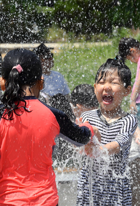 ▲ 낮 최고기온이 30℃까지 올라가는 등 무더운 여름 날씨를 보인 26일 오후 수원시 한 바닥분수대에서 어린이들이 더위를 식히고 있다. 홍승남 기자 nam1432@kihoilbo.co.kr