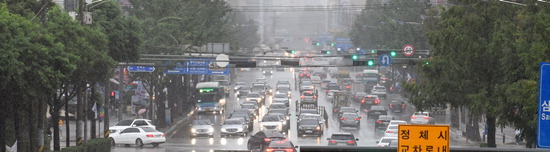 ▲ 비가 내린 15일 오후 수원시 팔달구 뉴코아사거리에서 차량들이 전조등을 켠 채 운행하고 있다.  홍승남 기자 nam1432@kihoilbo.co.kr