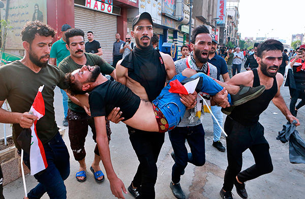 부상자 옮기는 이라크 반정부 시위대    (바그다드 AP=연합뉴스) 1일(현지시간) 이라크 바그다드 도심 타흐리르 광장에서 반정부 시위대가 경찰과 충돌로 부상한 남성을 옮기고 있다.