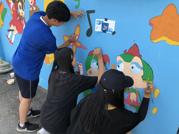 아츠히어로 동아리 학생들이 벽화 봉사활동을 하고 있다.