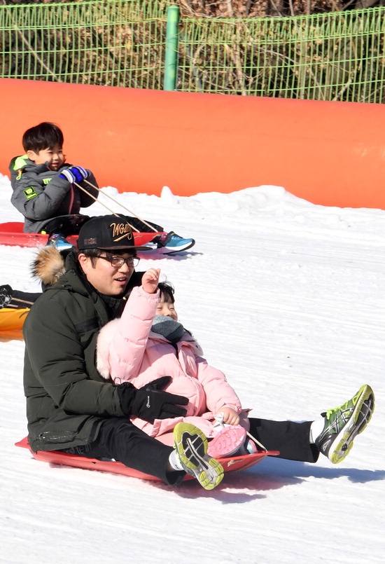 27일 오후 용인 한국민속촌 눈썰매장을 찾은 아이들이 엄마 아빠와 함께 눈썰매를 타며 휴일을 즐기고 있다.  용인=홍승남 기자 nam1432@kihoilbo.co.kr