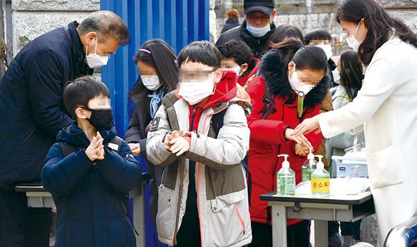 수원시의 한 초등학교 학생들이 29일 신종 코로나바이러스 예방을 위해 마스크를 쓰고 손 소독을 하며 등교하고 있다.  홍승남 기자 nam1432@kihoilbo.co.kr
