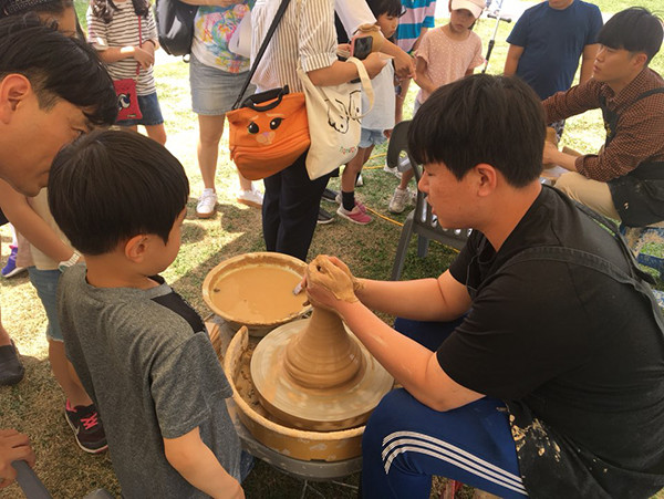 지난해 도자재단 ‘찾아가는 문화아카데미’에 참가한 어린이가 물레를 사용하는 법을 배우고 있다.