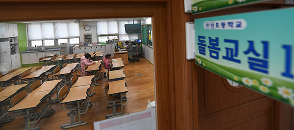 개학연기로 운영된 수원시 한 초등학교의 긴급돌봄교실에서 학생들이 마스크를 쓴 채 앉아 있다. <기호일보 DB>