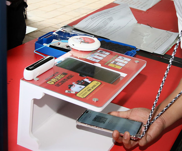 지난 24일 수원 케이티 위즈파크에서 입장객 휴대전화의 QR 코드를 전용 앱에 인식시켜 입장하는 과정을 테스트하고 있다.<제공=kt위즈>