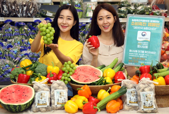 28일 이마트 서울 성수점 농산 매장에서 모델들이 농산물 할인 행사를 소개하고 있다. 이마트는 농림축산식품부와 30일부터 8월 5일까지 농산물 할인 혜택을 통해 국내 농가 돕기 및 내수 활성화에 나선다.  <이마트 제공>