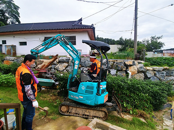 수원시 율천동 주민들이 미니포클레인으로 충북 제천시 수해지역 복구 작업을 벌이고 있다.
