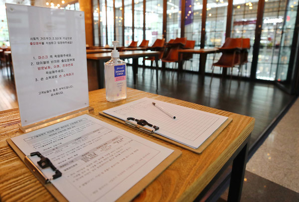 사회적 거리두기 2.5단계가 시행되고 있는 지난 31일 한 카페 입구에 이용 고객이 작성해야 하는 입장 명부가 놓여 있다. /사진 = 연합뉴스