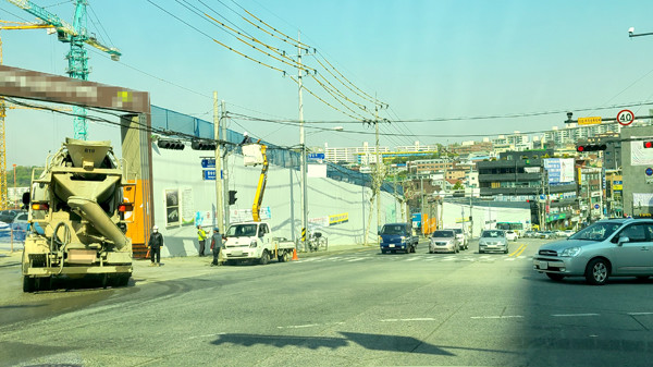 성남재개발 금광1구역의 주출입구인 6번 게이트 앞 황송삼거리에서 한 레미콘 차량이 반대편 차량의 주행 신호에도 불구하고 불법 좌회전을 하고 있다.