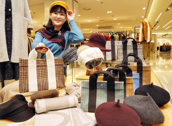 19일 서울 현대백화점 무역센터점 5층 폼스튜디오 매장에서 직원이 간절기 대표 아이템인 스카프·모자 등 패션 아이템을 선보이고 있다.  <현대백화점 제공>