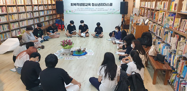 학생들이 마을 도서관에 모여 앉아 대화를 나누고 있다.
