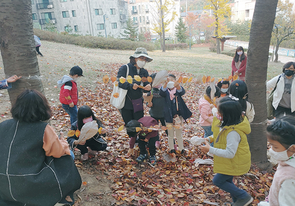 의왕시 ‘놀이터 플러스 사업’ 숲놀이 프로그램 참여자들이 낙엽으로 숲을 꾸미고 있다.