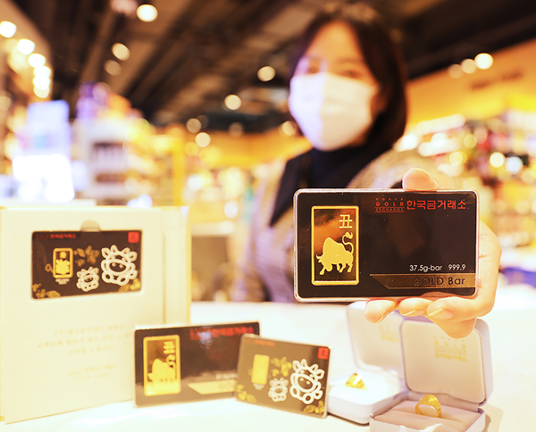 이마트24가 한국금거래소와 손잡고 18일부터 24일까지 금 선물 세트를 한정판매한다고 17일 밝혔다. 사진은 이날 서울 이마트24 성수대우점에서 소 문양 골드바 등 금 선물 세트를 소개하는 모델.  <이마트24 제공>