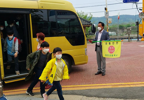 김희동 교감이 등굣길 차량 안전 통제에 나서고 있다.