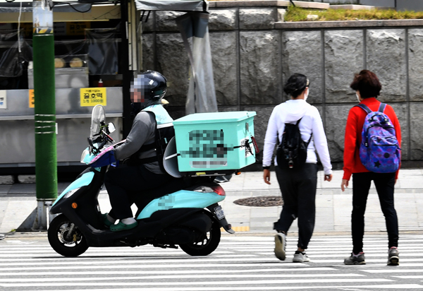 26일 인천시 미추홀구의 거리에서 오토바이 운전자가 횡단보도 파란불 신호에 도로 위를 이동하고 있다.   이진우 기자 ljw@kihoilbo.co.kr