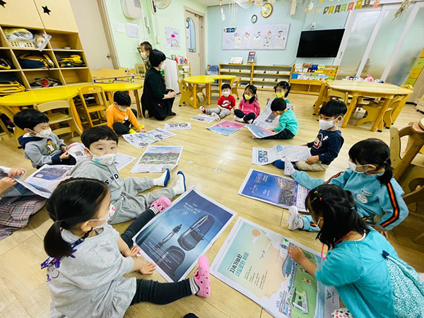 신문지를 활용한 수업을 듣는 신일유치원 유아들.