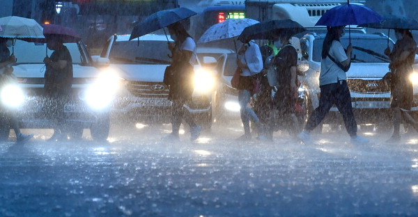 장마전선 정체의 영향으로 중부지방에 폭우가 쏟아진 8일 인천시 미추홀구의 한 거리에서 시민들이 비를 피하며 발걸음을 재촉했다.이진우 기자 ljw@kihoilbo.co.kr