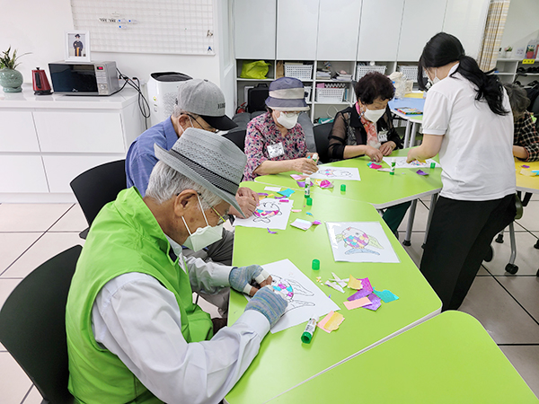 인창 기억나무 쉼터에서 색종이를 붙여 작품을 만들고 있는 어르신들.