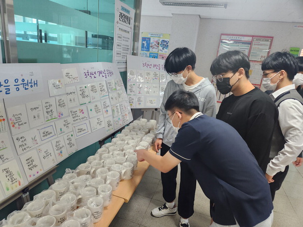 부천 수주고등학교 학부모회가 캘리그래피를 활용해 만든 수능 응원 머그컵에서 학생들이 메시지를 읽고 이름을 찾았다.  <수주고등학교 제공>