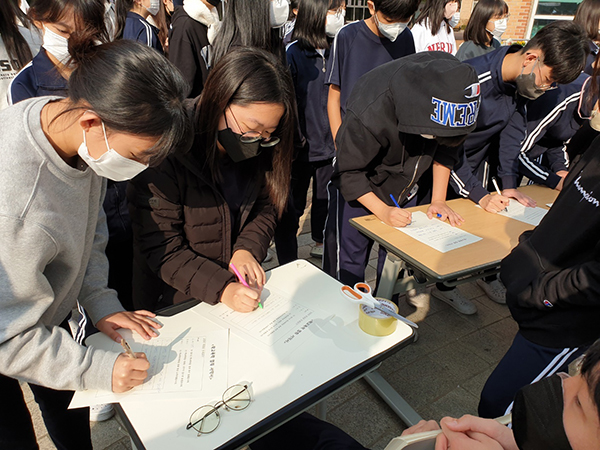 학교폭력 예방 캠페인에 참여해 학폭 근절 서약서를 작성하는 학생들.