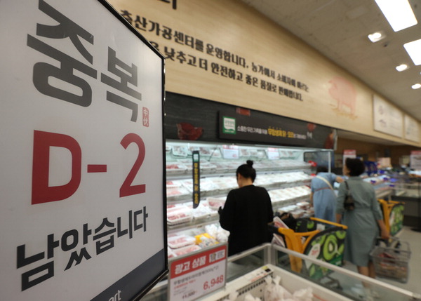 중복을 이틀 앞둔 19일 오후 서울의 한 이마트에서 시민들이 닭고기를 고른다. 유통업계는 중복(21일)을 앞두고 닭고기 등 보양식 재료 할인에 나섰다.  /연합뉴스