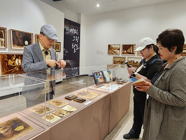 시민들이 강병규 작가의 ‘커피로 그린 철도’ 기획전시를 관람한다.