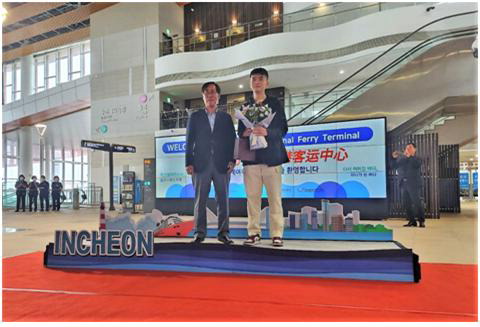 위동항운 박준영 총경리가 첫 하선 여객에게 축하 꽃다발을 전달했다.