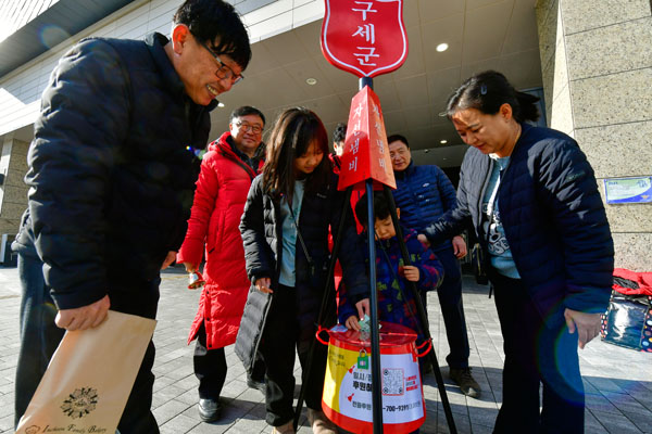 연말을 맞아 전국적으로 구세군 자선냄비 모금 캠페인이 시작된 가운데 4일 인천시 연수구 송도국제도시 한 쇼핑몰 앞에서 어린이들이 성금을 넣는다.  이진우 기자 ljw@kihoilbo.co.kr