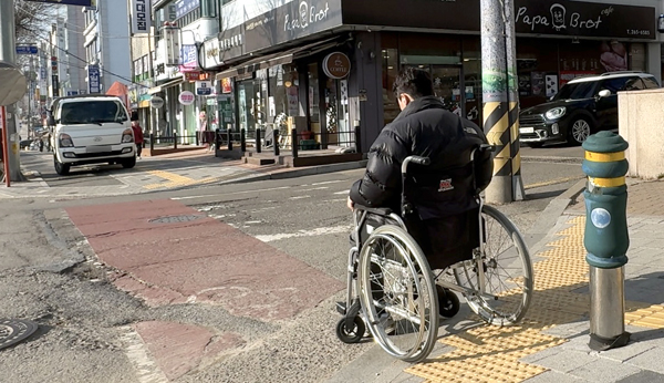 13일 오전 8시께 휠체어를 타고 하루 살이 체험에 나선 기호일보 기자가 울퉁불퉁한 바닥을 힘겹게 이동했다.