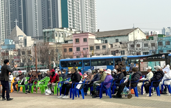 27일 동인천역 북광장에서 배회하던 노인들이 교회 연설을 듣는다.