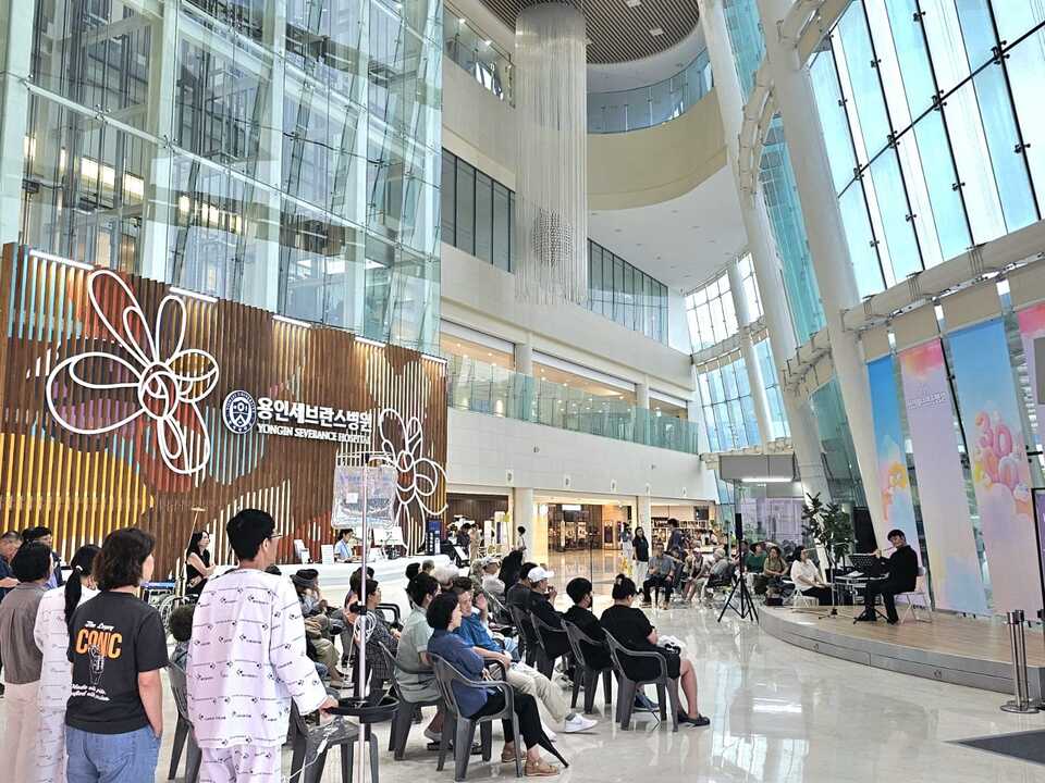 세이브월드가 8일 오후 용인 세브란스병원 1층 로비에서 힐링콘서트를 열어 환자들이 플루트 연주를 감상하고 있다. <세이브 월드 제공>